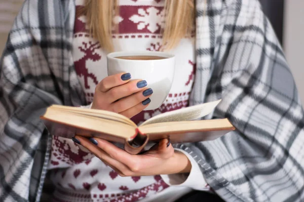 女の子飲む熱いお茶や読書は 長い冬の夜自宅予約します 地球温暖化とレトロな毛布で覆われた女性 寒さと冬のコンセプト 間近で 選択と集中 — ストック写真