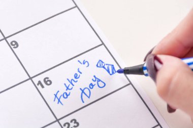 Keçeli kalem yazar word baba gün ile genç kız el ve çizim hatırlatma için Takvim yay kravat. Baba gün tatil kavramı. Yakın, seçici odak