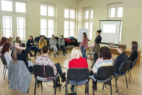 Niş, Sırbistan - 13 Şubat 2019: Grup birlikte daire gülümseyen ve büyük sınıfta iki öğretmen ile konuşurken sandalye üzerinde oturan bir grup tartışma sahip genç üniversite öğrenci