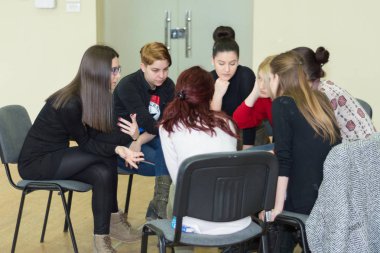 Niş, Sırbistan - 13 Şubat 2019: Takım işbirliği toplantı başlatmak kavramı. Birlikte çalışan ve bir daire sandalyelere oturan kadın çeşitliliği gençler. Yakın, seçici odak
