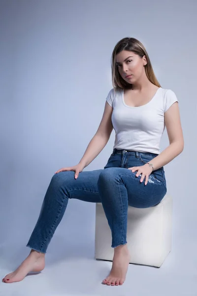 Menina Bonita Jeans Azul Pés Descalços Sentado Banco Cubo Branco — Fotografia de Stock