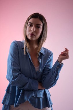 Ciddi olan kadın el ve parmak kamera, pembe arka plan izole Studio bakarak mavi gömlekli havada. Kız portre ve moda kavramı. Yakın çekim