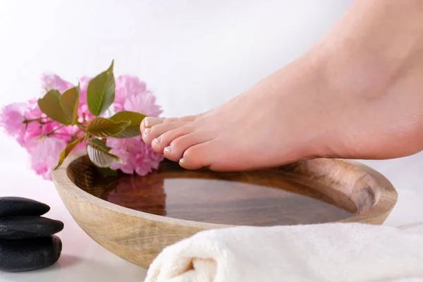 Pieds Féminins Sur Bol Bois Avec Eau Des Fleurs Roses — Photo