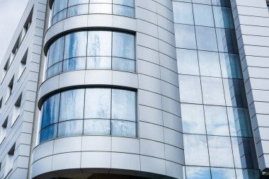 Modern bina temiz cephe ve bulutlu gökyüzü yansıması ile pencereler. Modern mimari ve dış konsept. Yakın çekim, seçici odak