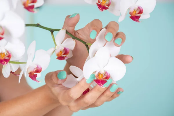 Mano Femenina Con Manicura Color Turquesa Las Uñas Flores Orquídeas — Foto de Stock