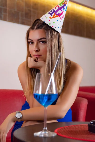 Młoda Śliczna Dziewczyna Czapką Urodzinowa Głowie Siedzi Restauracji Picia Błękitnej — Zdjęcie stockowe