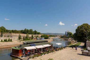 Nis, Sırbistan - 28 Ağustos 2019: Nisava Nehri üzerindeki raft restoranı ve Sırbistan'ın Niş kentinde güneşli yaz gününde bir rıhtım
