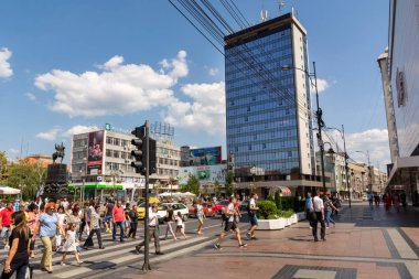Niş, Sırbistan - 28 Ağustos 2019: Sırbistan'ın Niş kentinde yaz güneşli gününde arka planda şehir merkezinde ve modern binada yaya geçidinde yürüyen birçok kişi