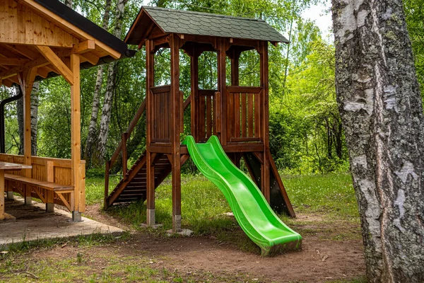 stock image Wooden children house for playing with slide toys in the resort forest on a sunny summer day. The resort, tourism, and traveling concept. Close up, selective focus