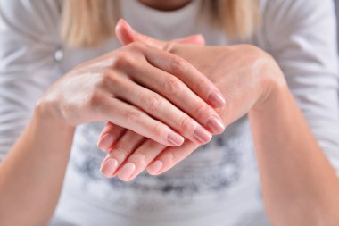 Güzellik stüdyosunda çıplak ve doğal ojeli elleri olan bir kız. Güzel renkli tırnakları olan kadın elleri. Manikür ve kadınlık kavramı. Yaklaş, seçici odaklanma