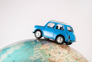 NIS, SERBIA - 8 Ocak 2018: Minyatür oyuncak araba Mini Morris, beyaz arka planda coğrafi dünya küresi üzerine. Seyahat kavramı