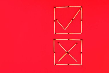 Kırmızı arkaplandaki kibrit kutularını doğru ve yanlış imzalayın