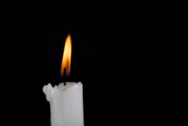 Siyah arka planda beyaz parafin mumu yanıyor. Kapatın. Metin için boşluk