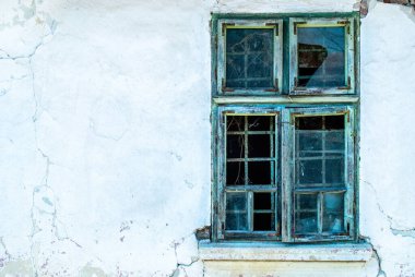 Eski evin yıkılmış duvarında güpegündüz duran eski bir pencere.