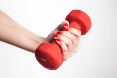 Beyaz arka planda kırmızı halterli bir kadın eli var. Kapat.