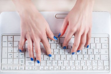 Beyaz dizüstü bilgisayarda yazı yazan kadın elleri. Üst görünüm, kapat
