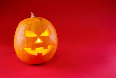 Ürkütücü Cadılar Bayramı kabağı kırmızı üzerine izole edilmiş ve mesaj için boşluk bırakılmış