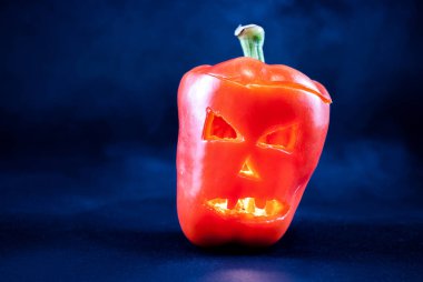 Kızgın kötü biberler koyu renkli ve tütsülenmiş arka planda turuncu renkte. Cadılar Bayramı konsepti