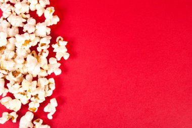 Kırmızı zemin üzerinde patlamış mısır, boş alan, üst görünüm.