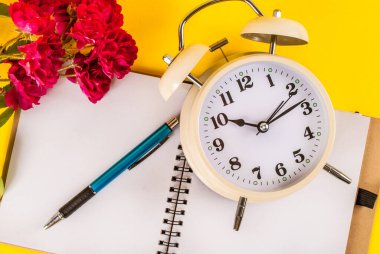 Eski saat, kırmızı gül çiçeği, defterde kalem, eski konsept resim