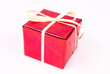 Beyaz arka planda krem rengi fiyonklu kırmızı hediye kutusu