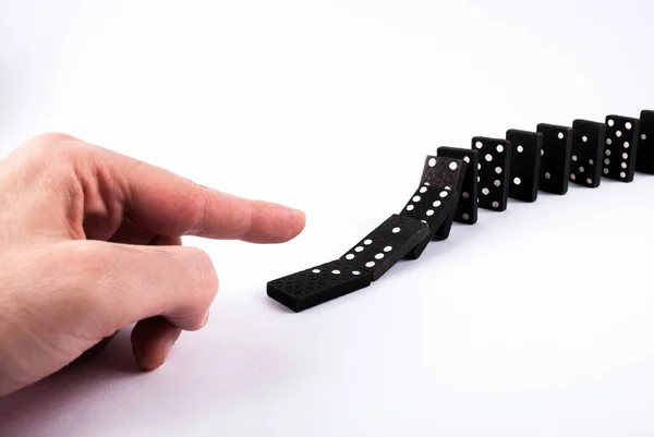 Finger push dominoes tiles and they fall isolated on a white background. Domino effect