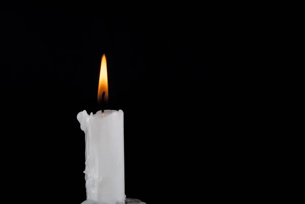 石蜡蜡烛燃烧和用黑色背景和文字空间隔开的旧烛台 — 图库照片