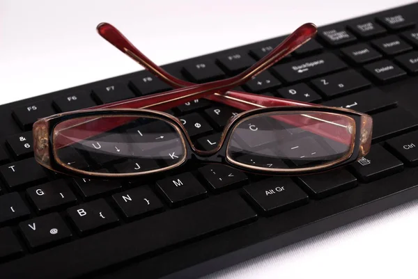 コンピュータのキーボードの赤いメガネを閉じてください 選択的焦点 — ストック写真