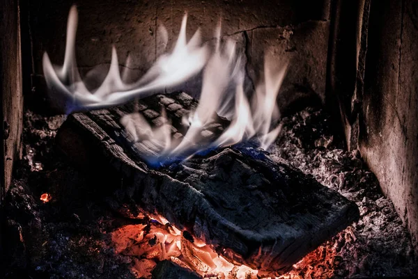 Wood burning in old stove with embers. Close up