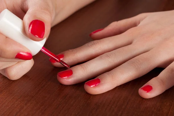 Menina Pintar Unhas Com Esmalte Vermelho Mesa Madeira Fechar — Fotografia de Stock