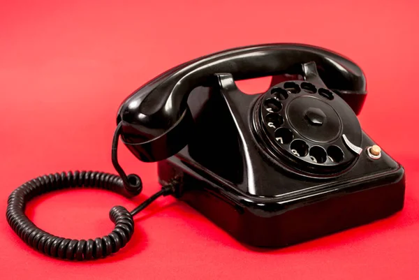 Παλιό Μαύρο Τηλέφωνο Απομονωμένο Κόκκινο Φόντο — Φωτογραφία Αρχείου