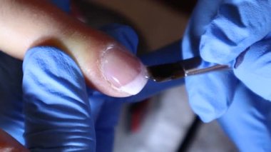 Güzellik uzmanı, güzellik salonundaki bir fırçayla koruyucu jel sürüyor.