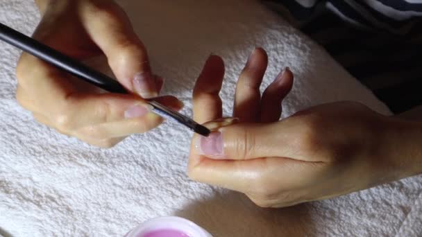 Femeia aplică un strat subțire de gel de protecție pe unghii cu o perie — Videoclip de stoc