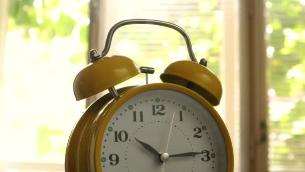 Primer plano de una campana de un reloj despertador amarillo vintage que está marcando segundos — Vídeo de stock