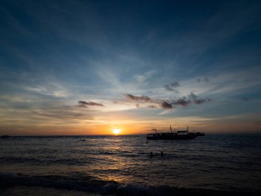 Filipinler plajında çarpıcı bir gün doğumu. Dalgıçlar sabah erkenden dalmayı bekliyor..