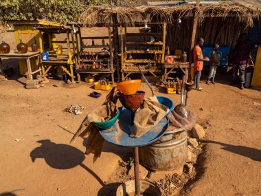 Benin / Afrika - 01 / 01 / 2020. İlkel sokak benzin istasyonu. İki çocuk şişelerden yakıt satıyor..