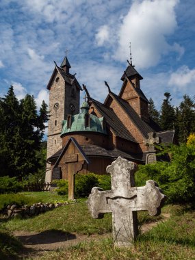 Karpacz / Polonya - 24 / 07 / 2020. Eski tahta tapınak Vang (Wang). Norveç 'in Vang kentinden nakledilen ve 1842' de Karpacz 'da yeniden inşa edilen Ortaçağ Norveç sazlık kilisesi. Önündeki eski mezarlık..