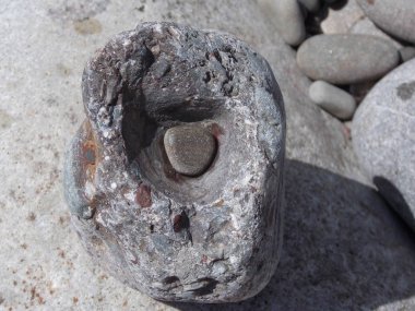 Büyük bir taşın içindeki oyuktaki küçük taşın görüntüsü.
