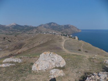 Küçük deniz kasabasının yanındaki büyük taşın manzarası..