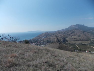 Dağ yamacından deniz kıyısındaki küçük kasabanın manzarası..