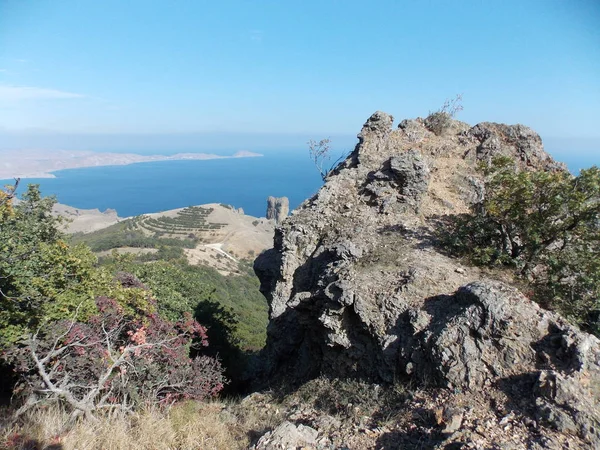 Mavi denize karşı kaya dağlarının görünümü.