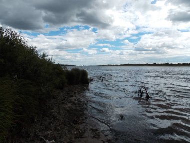 Gökyüzüne karşı banka ile büyük nehir görünümü.