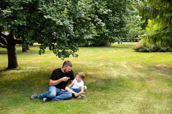 Baba ve oğul parktaki çimlerin üzerinde oturuyorlar. Baba oğluna ders veriyor, bir hikaye anlatıyor. Akraba sevgisi. Sevgi. Güven ilişkisi