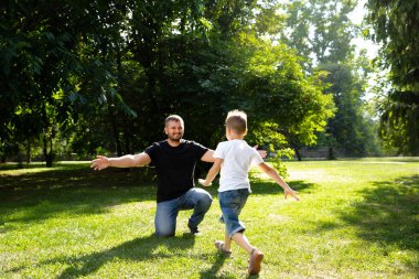 Küçük çocuk babasının kollarına doğru koşuyor. Aile mutluluğu. Uzun zamandır beklenen toplantı. Baba oğul sevgisi