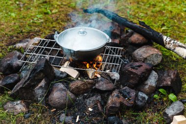 Açık havada yaz tatili. Dağlardaki ormanda kamp yapmak. Kamp ateşinde kazan. Yemek kampı yemeği..