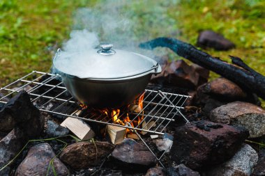 Açık havada yaz tatili. Dağlardaki ormanda kamp yapmak. Kamp ateşinde kazan. Yemek kampı yemeği..