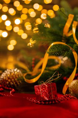 Noel süslemeleri olan Xmas afişi: koni, toplar, bant, boncuklar, hediye kutusu ve çelenk arka planında Noel ağacı. Kopyalama. Yeni yıl tebrik kartı..