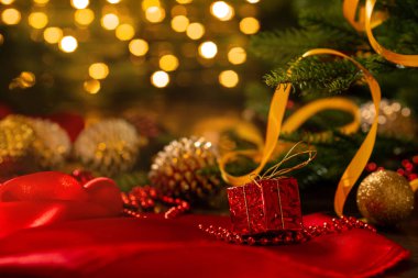 Noel süslemeleri olan Xmas afişi: koni, toplar, bant, boncuklar, hediye kutusu ve çelenk arka planında Noel ağacı. Kopyalama. Yeni yıl tebrik kartı..