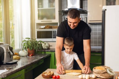 Şefkatli baba, anaokulu çocuğuna kurabiye hazırlamasında, gülümseyen babaya, küçük çocukla yemek pişirmede, hafta sonları mutfakta birlikte yemek pişirmede yardım eder.
