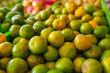 Geleneksel pazarda bir sürü yeşil portakal meyvesi. Mandalina meyvesi